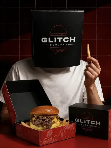 Instagram post: someone wearing a Glitch box over their head, holding a fry